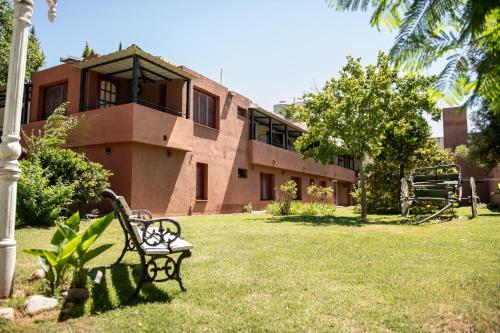a park bench in front of a building at Los Robles in Villa Cura Brochero
