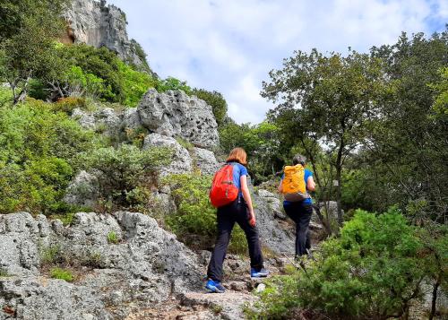 two people with backpacks walking on a mountain trail at Villaggio Turistico Tecciù di Cuppi in Magliolo