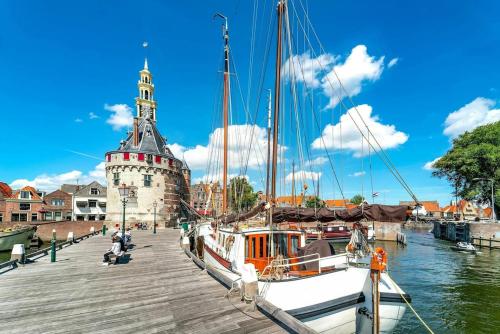 a boat is docked at a dock with a tower at Het Haven Huysje in Hoorn