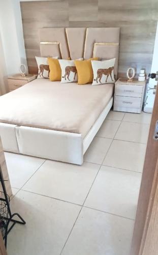 a bedroom with a large white bed with yellow pillows at beautiful apartment in tanger beach in Hauara