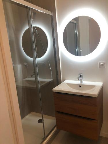 une salle de bain avec un lavabo et une douche avec deux miroirs circulaires dans l'établissement La Tronche studio climatisé wifi proche CHU, à La Tronche