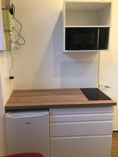 - une cuisine avec un comptoir et un four micro-ondes dans l'établissement La Tronche studio climatisé wifi proche CHU, à La Tronche