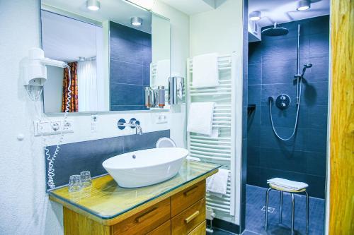 a bathroom with a sink and a shower at Holzschuhs Schwarzwaldhotel in Baiersbronn
