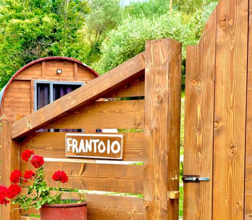 a wooden dog house with a sign on a fence at Le Botti Fiorentine in Reggello