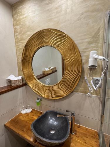 a bathroom with a black sink and a mirror at Pension & Restaurant Atmosféra in Loket