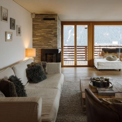 a living room with a couch and a fireplace at Bergwelt Grindelwald Residence in Grindelwald