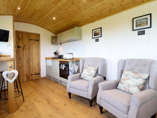a living room with two chairs and a kitchen at Defaid Cymreig in Oswestry