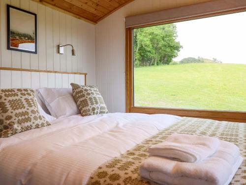 a bed in a room with a large window at Defaid Cymreig in Oswestry