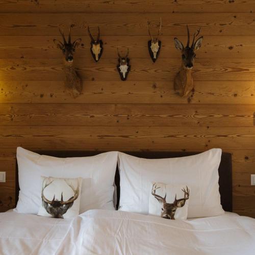 a bedroom with a bed with antlers on the wall at Bergwelt Grindelwald Residence in Grindelwald