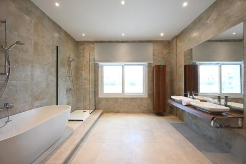 ein Badezimmer mit einer Badewanne, 2 Waschbecken und einer Badewanne in der Unterkunft Solana luxury mansion in Kairo