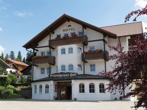 ein großes weißes Gebäude mit einem Schild drauf in der Unterkunft Hotel Eisensteiner Hof in Bayerisch Eisenstein