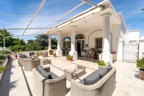 an outdoor patio with wicker chairs and tables at Hotel Bellavista in Anacapri