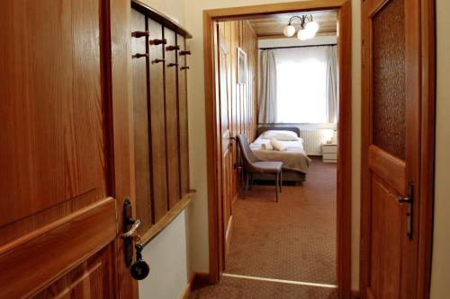 a hallway with a door and a room with a bed at Willa 1910 in Karpacz