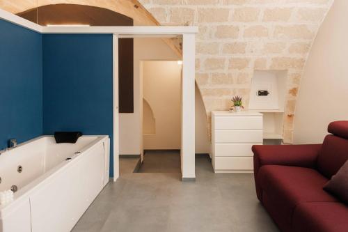 sala de estar con sofá rojo y paredes azules en Suite Polignani, en Monopoli