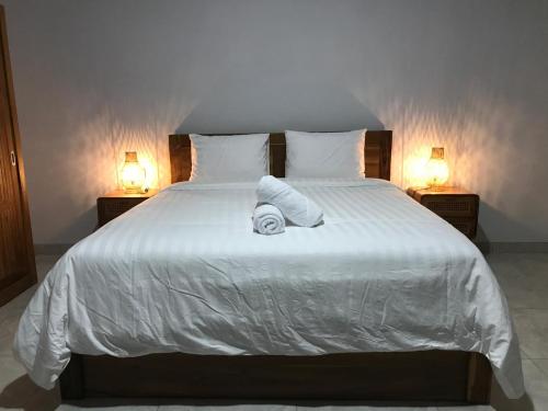 un lit avec deux oreillers et des serviettes dessus dans l'établissement Rumah Asri Devarastra #1, à Amed