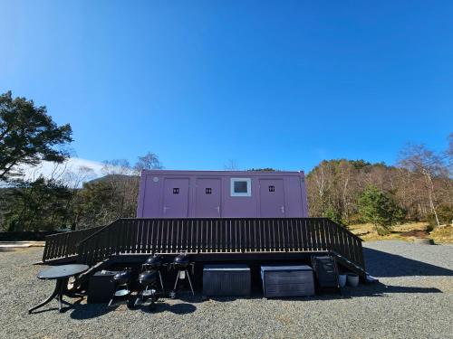 a building with a table and chairs in a parking lot at NorGlamp Glamping in Hjelmeland