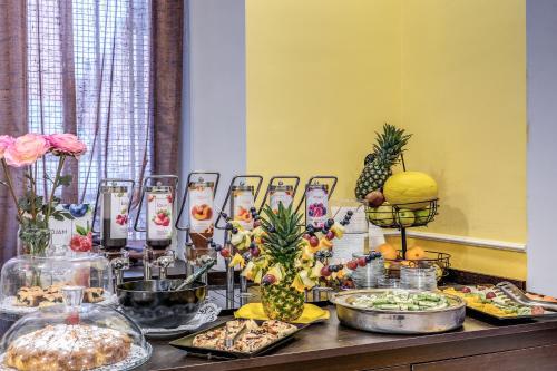 a buffet of food with pineapple and other foods at Hotel Ottaviano Augusto in Rome