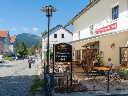a street sign in front of a building with tables and chairs at Hotel Eisensteiner Hof in Bayerisch Eisenstein