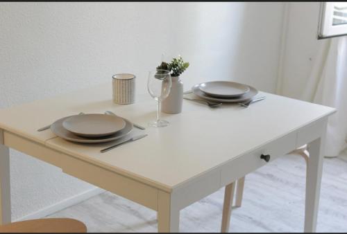 a white table with two plates and a glass at Studio-parking-wifi-Disney-Val d'Europe 10 mn in Montévrain