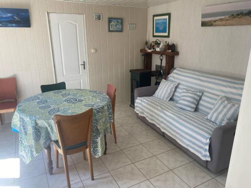 un salon avec une table et un canapé dans l'établissement Maison Familiale en bord de plage, à Lacanau