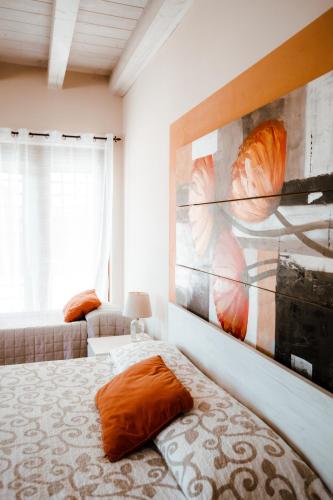 a bedroom with two beds and a painting on the wall at Residence Cà di Capri in Bussolengo
