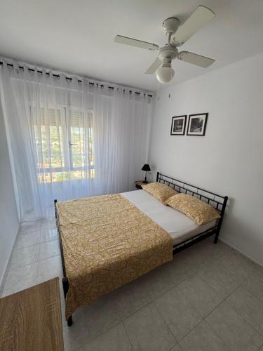 Un dormitorio con una cama y un ventilador de techo. en Everest Grao y Playa de Gandia, en Gandía