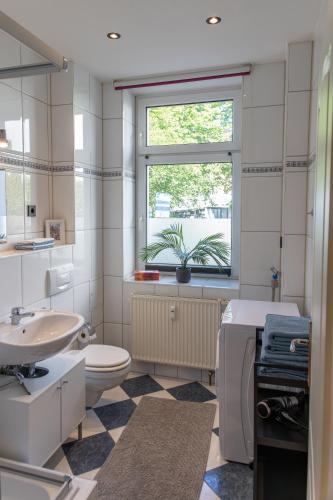 a bathroom with a sink toilet and a window at CityFlair in Rostock