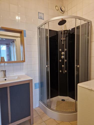 une douche avec une porte vitrée dans une salle de bain dans l'établissement Gite villa Diana piscine, à La Celle-sous-Gouzon
