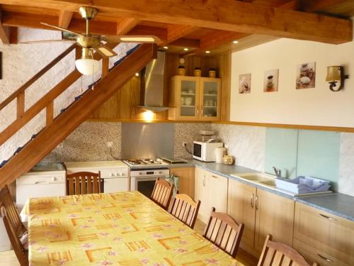 une cuisine avec une table en bois et une salle à manger dans l'établissement Gite villa Diana piscine, à La Celle-sous-Gouzon