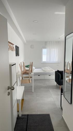 a white living room with a table and chairs at Boardinghouse Living in Gemmingen