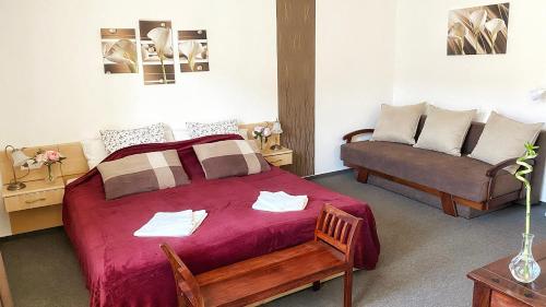 a bedroom with a large bed and a couch at Kala Thermal Lake Wellness Apartment in Zalakaros