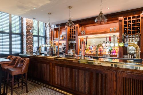 Un bar en un restaurante con un mostrador y sillas. en Pencelli Hotel, en Treorky