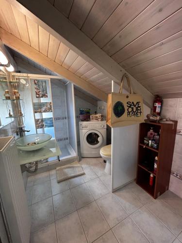 a bathroom with a sink and a washer and dryer at You & Me, near the sea and Patras University in Patra