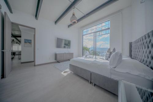 a large bedroom with a large bed and a large window at Mountain Mansion Pool, Jacuzzi Epic Medellin View in Envigado