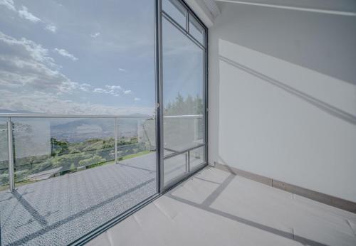 an empty white room with a large glass window at Mountain Mansion Pool, Jacuzzi Epic Medellin View in Envigado