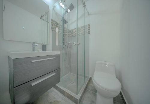 a bathroom with a toilet and a glass shower at Mountain Mansion Pool, Jacuzzi Epic Medellin View in Envigado