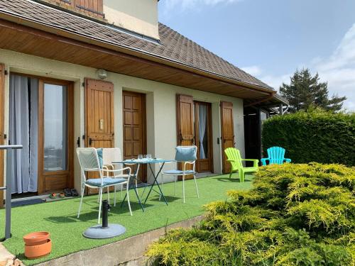 a patio with chairs and a table on a lawn at belle vue in Saint-Sauveur-de-Peyre