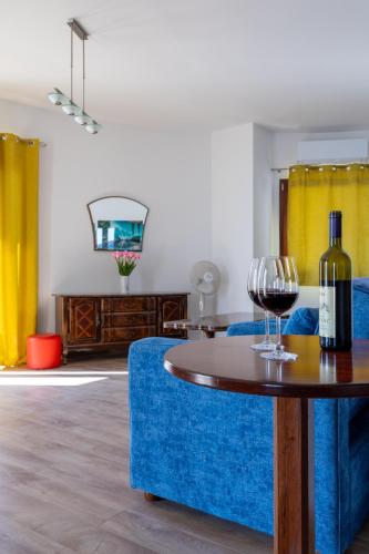 ein Zimmer mit einem blauen Sofa und einem Tisch mit Weingläsern in der Unterkunft Adrian in Rafailovici