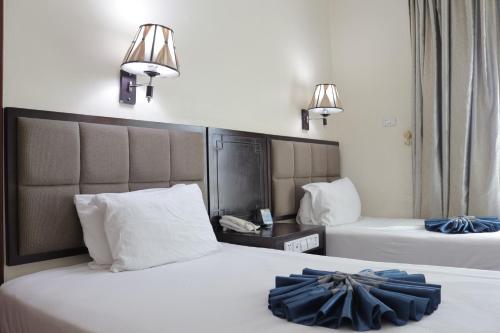 a hotel room with two beds and two lamps at Blue Birds International Hotel in Addis Ababa