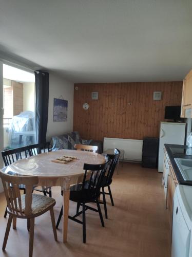 une cuisine et une salle à manger avec une table et des chaises dans l'établissement Au pied des piste T4 51m2 avec garage Le Pavin, à Besse-et-Saint-Anastaise