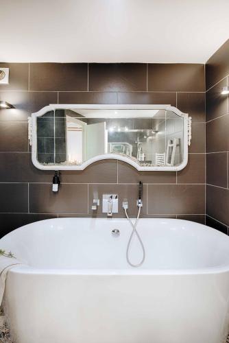 a white tub in a bathroom with a mirror at Can Cruanyes in Sales del Llierca