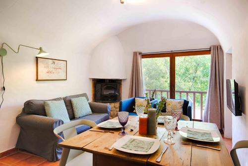 a living room with a table and a couch at Can Cruanyes in Sales del Llierca