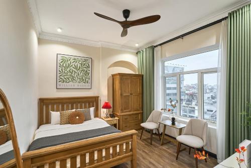 ホーチミン・シティにあるThe Passion Lux Airport Hotel Apartmentのベッドと机と窓のある寝室