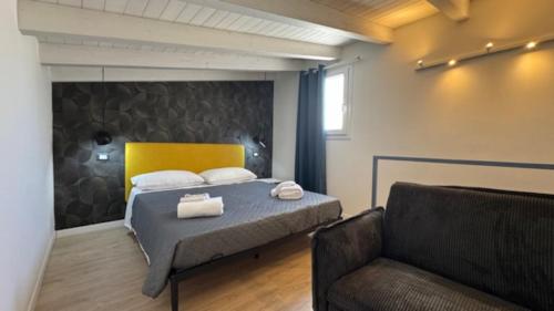 1 dormitorio con 1 cama con silla y sofá en Casarkeb, en Terrasini