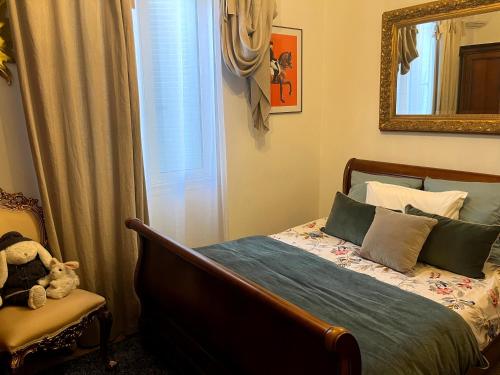une chambre avec un lit, une chaise et un miroir dans l'établissement Appartement T3 centre ville, à Ajaccio