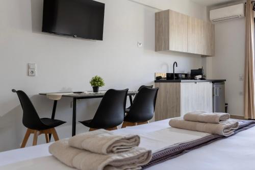 a room with a bed with chairs and a kitchen at NS Apartments Nydri in Nydri