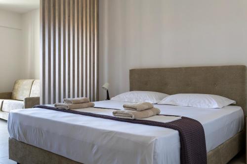a bedroom with a large bed with towels on it at NS Apartments Nydri in Nydri