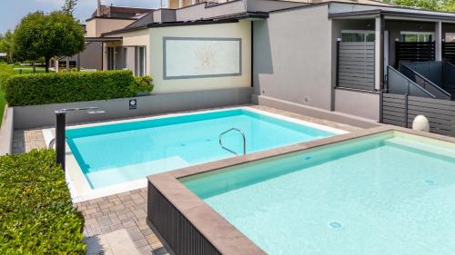 a swimming pool in front of a house at Aurora ApartHotel in Peschiera del Garda