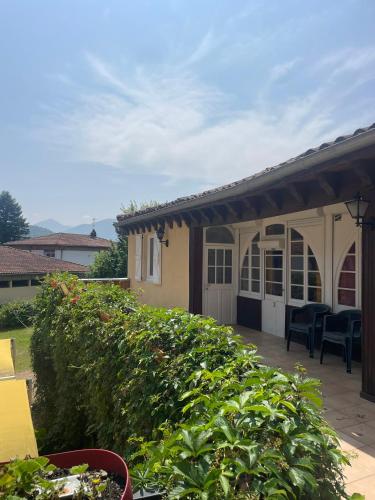 a house with a porch and a patio at Le Rocher in Barbazan