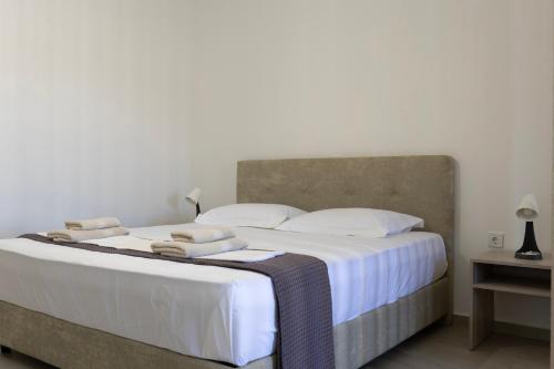 a bedroom with a large bed with white sheets and pillows at NS Apartments Nydri in Nydri